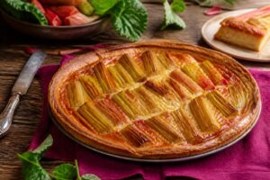 Tarte à la rhubarbe façon grand-mère, pâte brisée dorée et garniture crémeuse, sur fond de bois rustique