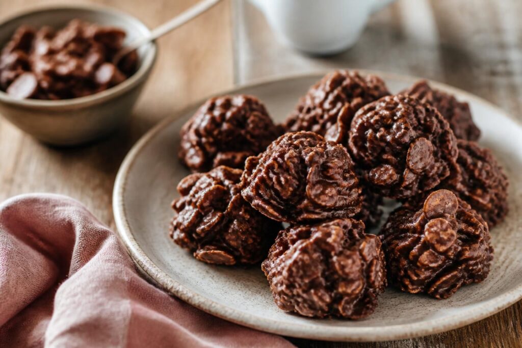 Roses des sables au chocolat noir, dressées sur papier sulfurisé, avec des corn flakes bien enrobés et un aspect croustillant et brillant